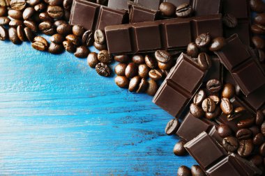 Siyah çikolata parçaları ve renk ahşap arka plan üzerinde kahve taneleri