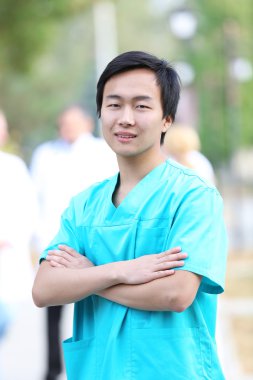 Tıbbi işçilerin odaklanmamış grup karşı duran genç gülümseyen doktor