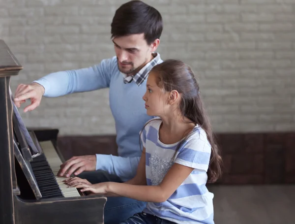 Professor e menina tocando piano — Fotografia de Stock