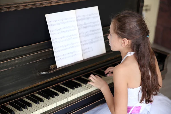 Prinses meisje speelt piano — Stockfoto