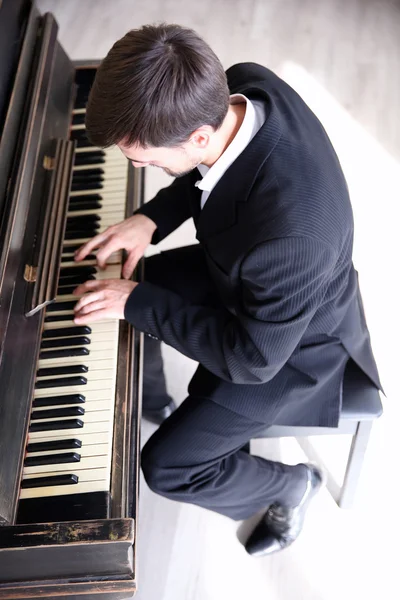 Mannen i svart kostym spelar piano — Stockfoto