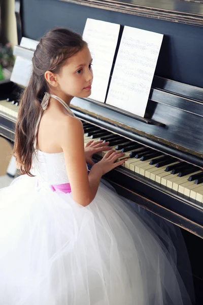 Vacker flicka spela på piano — Stockfoto