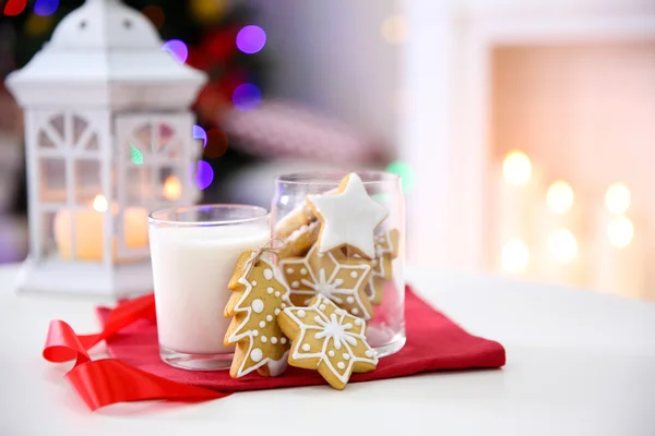 Рождественское печенье и стакан молока на столе дома — стоковое фото