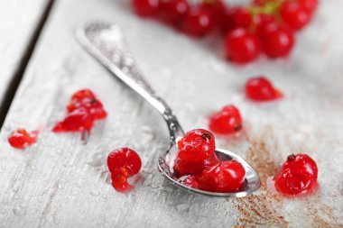 Ahşap masa üzerinde taze kırmızı kuş üzümü yakın çekim