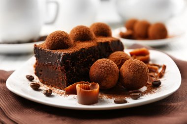 Slice of chocolate cake with a truffle on plate closeup clipart