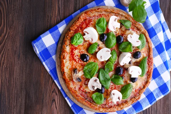 Gustosa pizza con verdure e basilico in tavola da vicino — Foto Stock