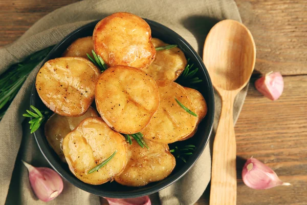 Смачна запечена картопля з розмарином в мисці на столі крупним планом — стокове фото