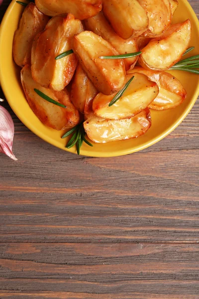 Baked potato wedges on wooden table, top view — Stock Photo, Image