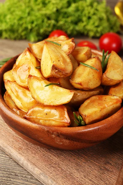 Cuñas de papa al horno en la mesa de madera, primer plano —  Fotos de Stock