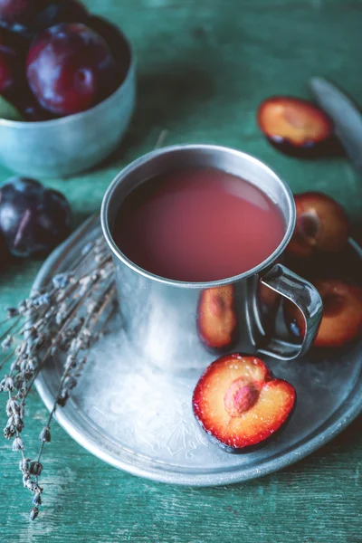 Delizioso succo di prugna con frutta sul tavolo di legno da vicino — Foto Stock