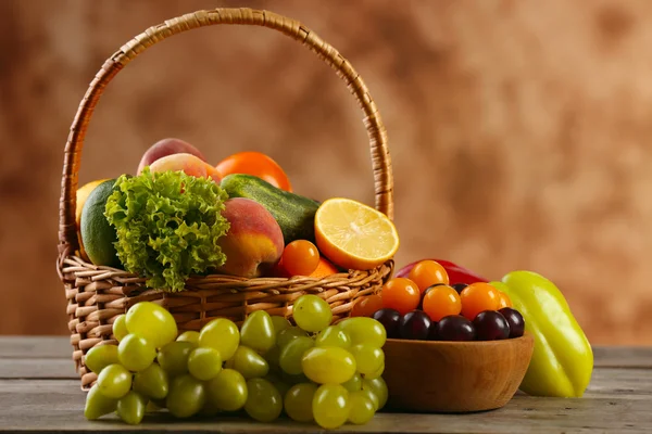 Haufen frisches Obst und Gemüse in Korb auf Holztisch in Großaufnahme — Stockfoto