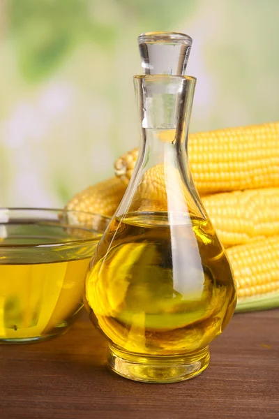 Бутылка масла со свежей кукурузой на ярком фоне — стоковое фото