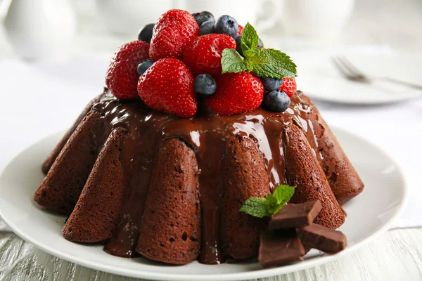 Delicious chocolate cake with strawberries in plate on table, closeup — Stock Photo, Image