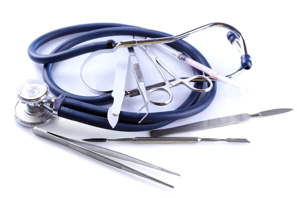 Estetoscopio e instrumentos quirúrgicos sobre fondo blanco, primer plano — Foto de Stock