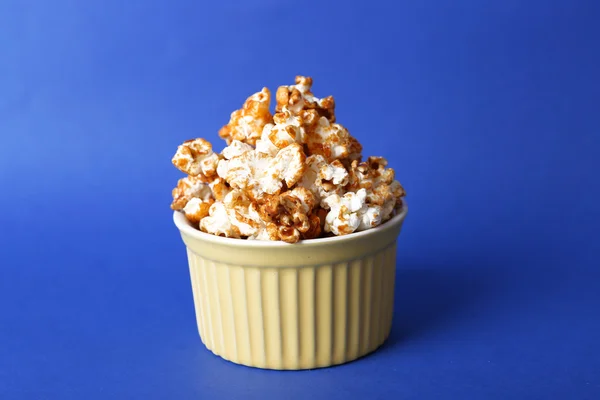 Sweet caramel popcorn on blue background — Stock Photo, Image