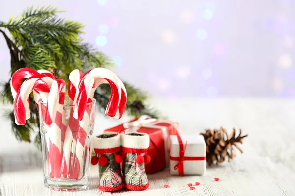 Canas de caramelo de Navidad en vidrio sobre mesa sobre fondo claro —  Fotos de Stock