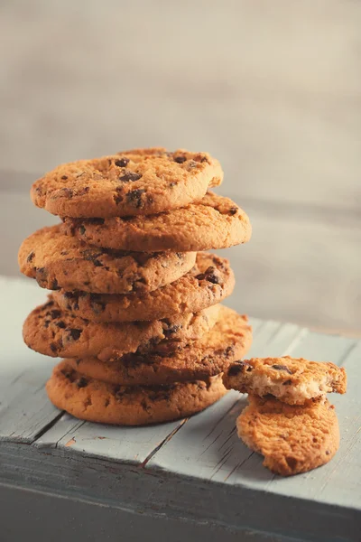 Biscotti con briciole di cioccolato su tavolo di legno blu su sfondo sfocato, primo piano — Foto Stock