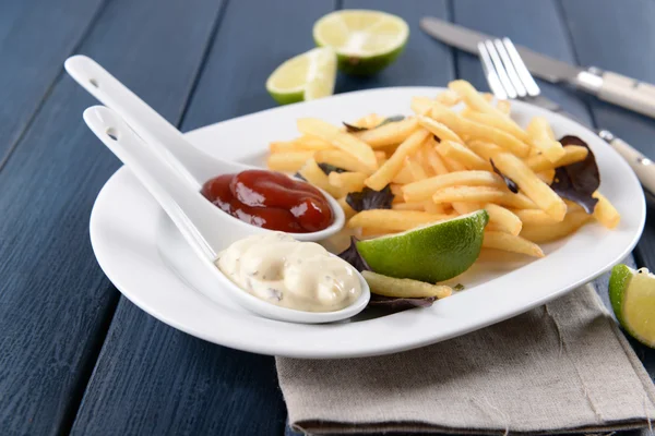 Batatas fritas francesas com molho e limão na bandeja branca — Fotografia de Stock