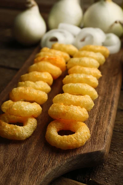 Anillos de virutas con salsa y cebolla en la tabla de cortar — Foto de Stock