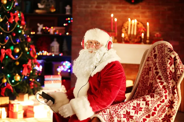 Papai Noel sentado com fones de ouvido — Fotografia de Stock
