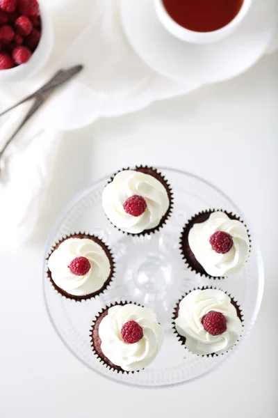 Gyönyörű csokoládé cupcakes tejszínnel és a málna, a táblázat — Stock Fotó