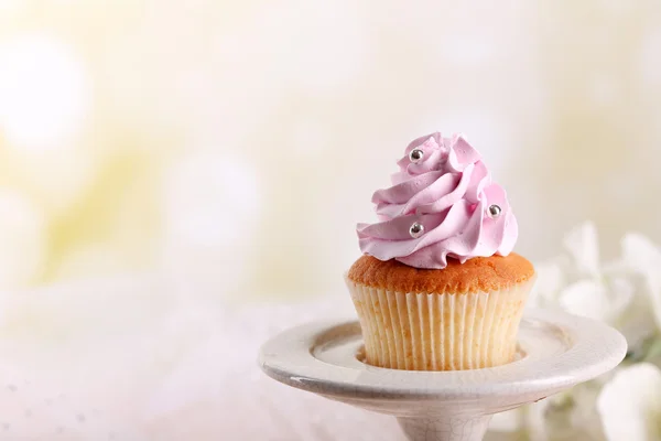 Leckere Cupcake am Stand, auf hellem Hintergrund — Stockfoto