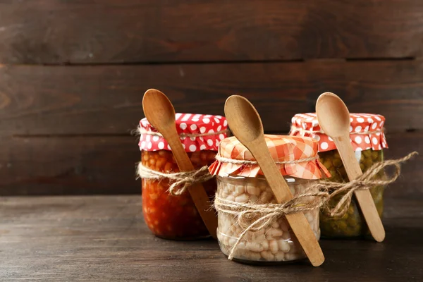 Glas mit eingelegten Erbsen und Bohnen auf Holzgrund — Stockfoto