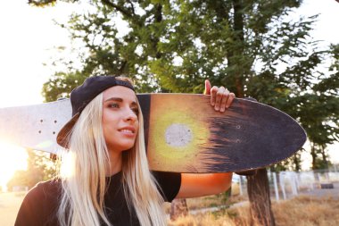 Buz pateni ile genç kadın doğa üzerinde kurulu