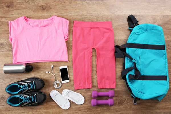 Equipamiento deportivo para mujer sobre fondo de madera — Foto de Stock