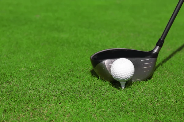 Golf club och bollen på ett grönt gräs — Stockfoto