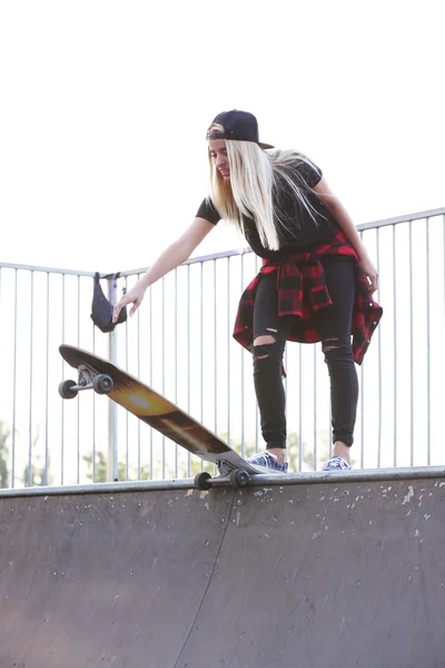 Jonge vrouw met schaatsen boord buiten — Stockfoto