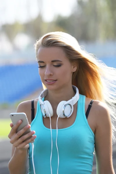 Jovem mulher ouvindo música no estádio — Fotografia de Stock