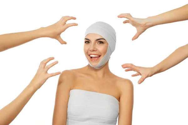 Jeune femme émotionnelle avec un bandage élastique sur la tête et les mains autour d'elle, isolée sur blanc — Photo