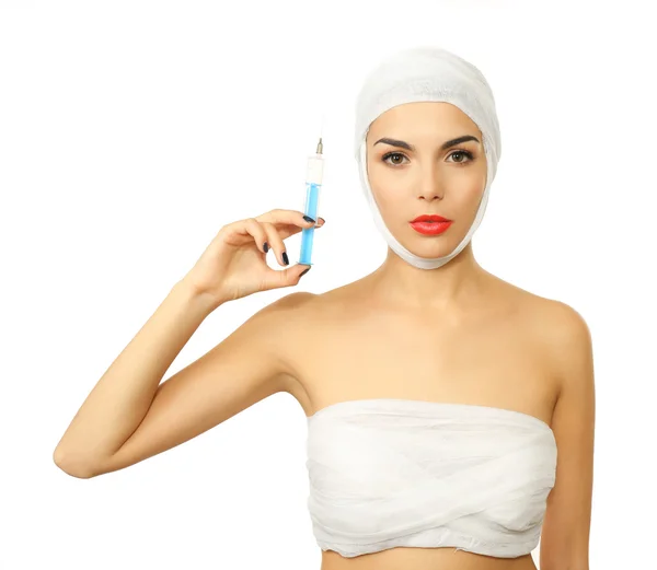 Mladá krásná žena s obvaz na její hlavě a hrudníku, držící injekční stříkačky, izolovaných na bílém — Stock fotografie