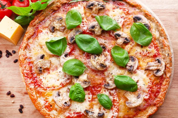 Gustosa pizza con verdure e basilico in tavola da vicino — Foto Stock