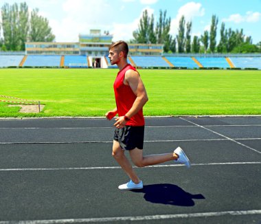 Genç adam stadyum üzerinde koşu