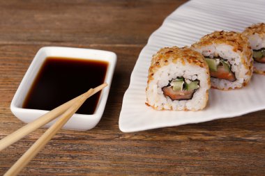 Ahşap masa üzerinde sos ve sopa ile rulo yakın çekim