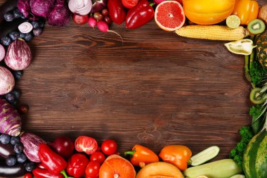 Parlak meyve ve sebze ahşap zemin üzerine yapılmış bir çerçeve