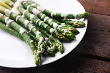 Ekşi krema soslu ahşap arka plan beyaz tabakta iştah açıcı kuşkonmaz