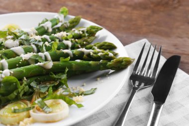 Ekşi krema sos soğan, peynir ve limon ahşap arka plan, beyaz tabakta iştah açıcı kuşkonmaz yakın çekim