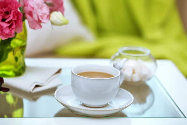 Cup of coffee on table in living room — Stock Photo, Image