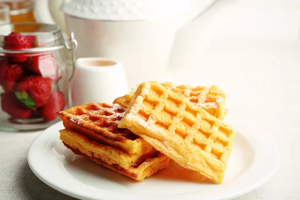 Sweet homemade waffles with fresh strawberries on plate, on light background — Stock Photo, Image