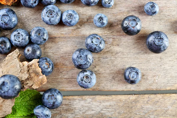 Bleuets mûrs savoureux avec des feuilles vertes sur la table en bois fermer — Photo