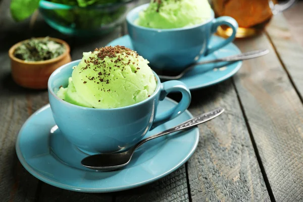 Es krim teh hijau buatan sendiri dalam cangkir, dengan latar belakang kayu — Stok Foto