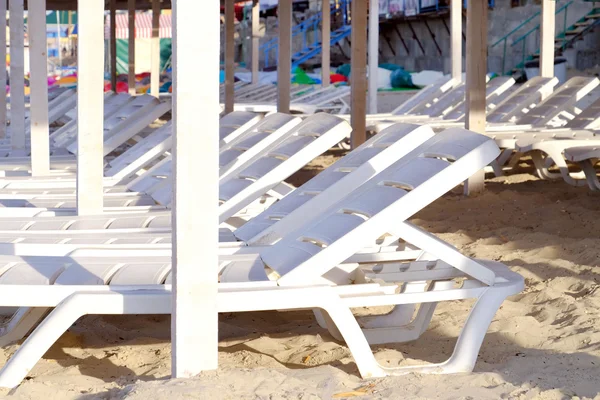 Camas de sol de plástico na praia de areia — Fotografia de Stock