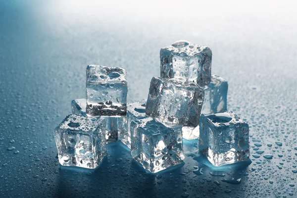 Derretendo cubos de gelo com gotas ao redor, de perto — Fotografia de Stock