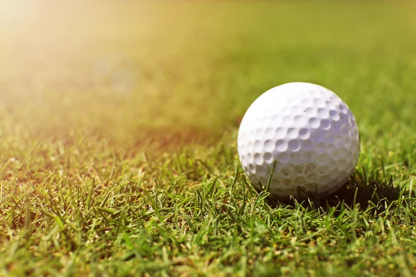 Pelota de golf en el labio de la taza en el campo de golf verde, de cerca — Foto de Stock