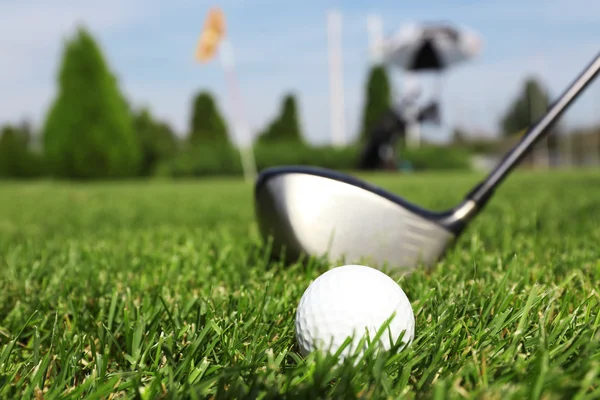 Гольф-клуб и мяч на зеленой траве — стоковое фото