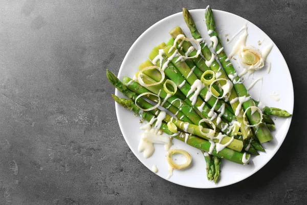 Hidangan asparagus sehat dengan irisan bawang di piring putih dengan latar belakang abu-abu — Stok Foto