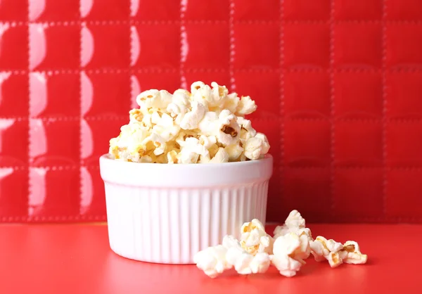 Salted popcorn on red background — Stock Photo, Image